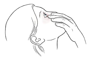 Woman leaning head back and pulling gently down on lower eyelid.