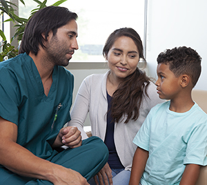 Health care provider talking to woman and boy.