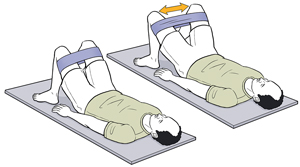 Man lying on floor with knees bent doing a hip exercise by opening legs against a resistance band.