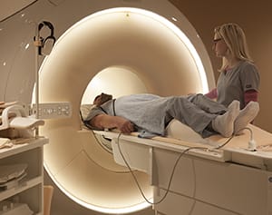 Technician preparing person for MRI scan.