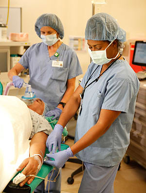 Doctors in operating room preparing man for surgery.