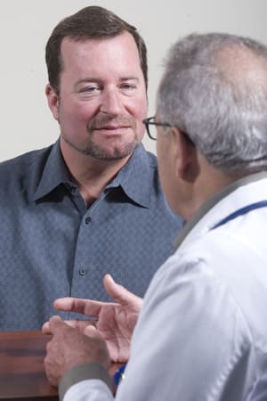Man and doctor sitting across from one another, talking.