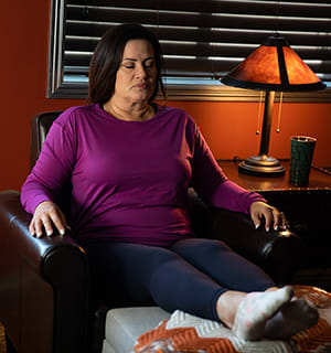 Female relaxing in chair with feet up.